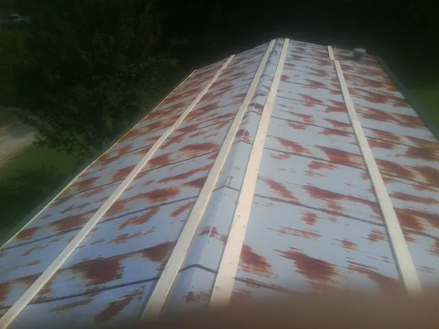 Rusted metal roof panels with new wood purlins before replacement — Storm Damage Roof Repair in Sag Harbor by Roofing Brothers
