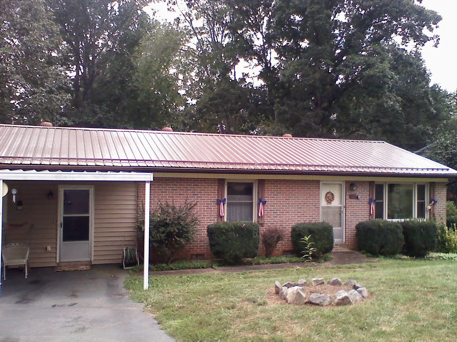 Bronze metal roof and carport on a brick ranch home — Roof Repair work by our crew in Sag Harbor